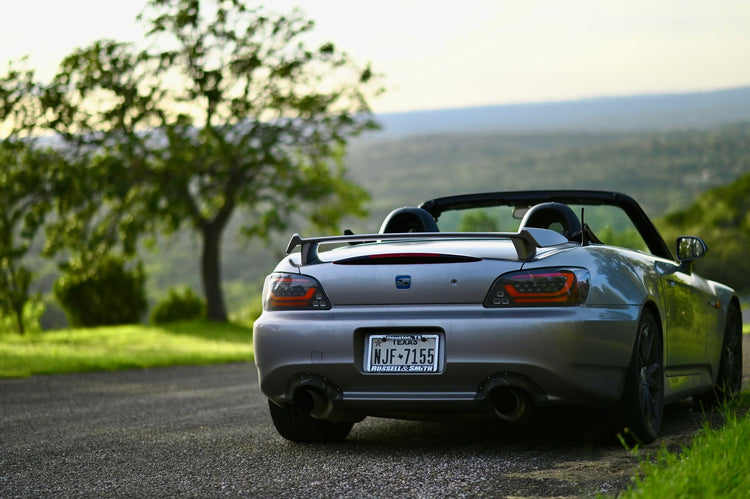 Grey Honda S2000 roadster photographed outdoors on a scenic road; illustrative guide photo